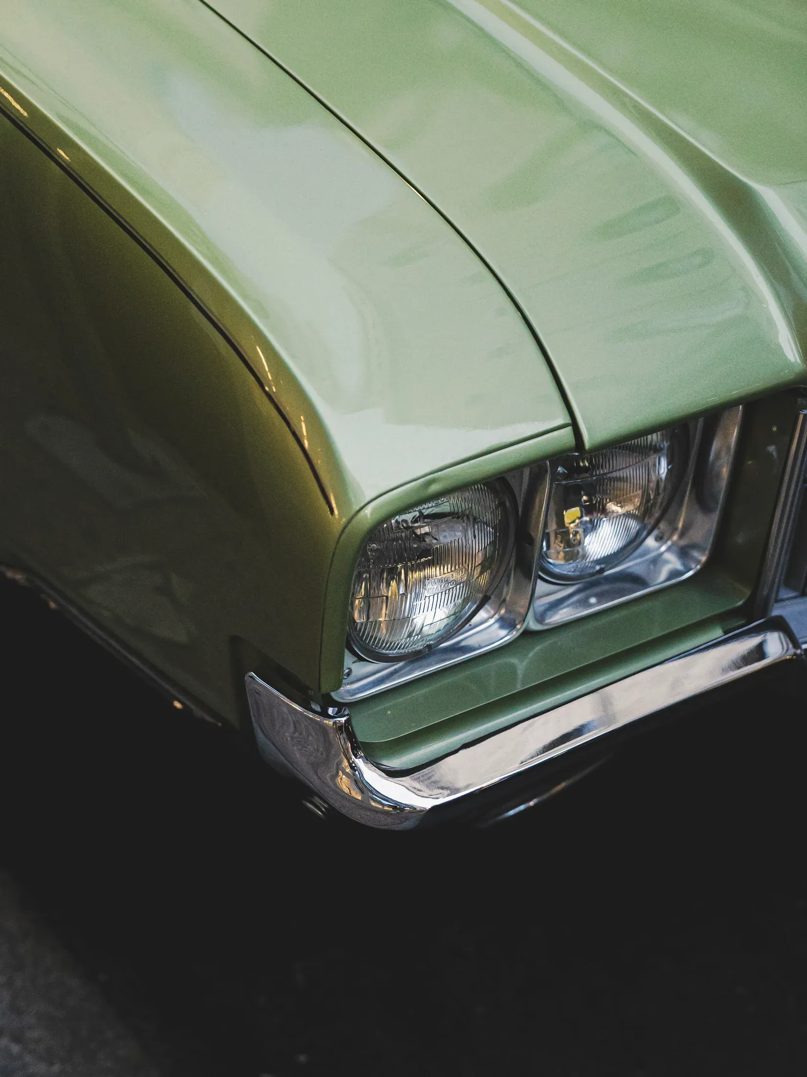 Detail of a green classic car on a city street.