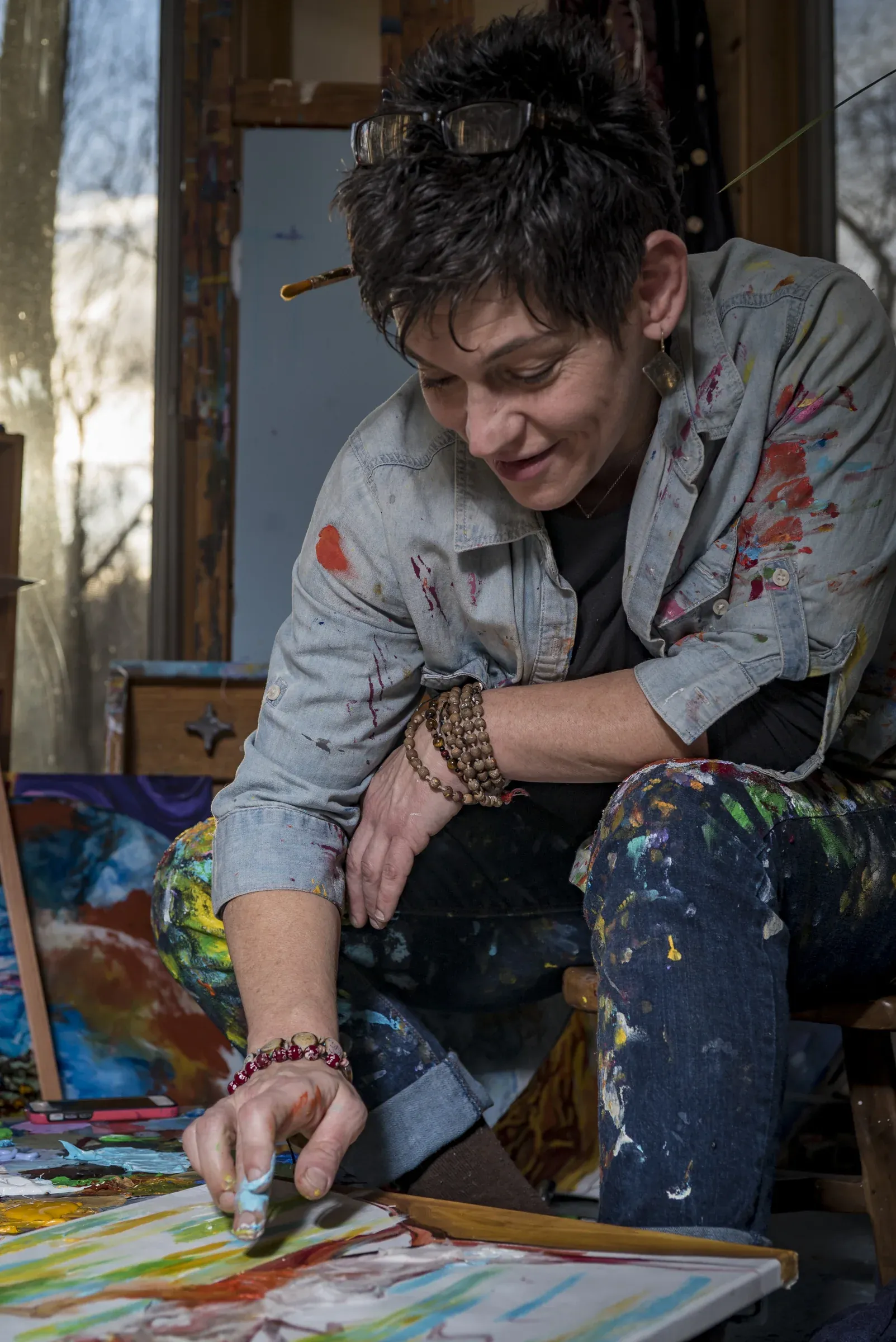 A painter working inside a light-filled studio.
