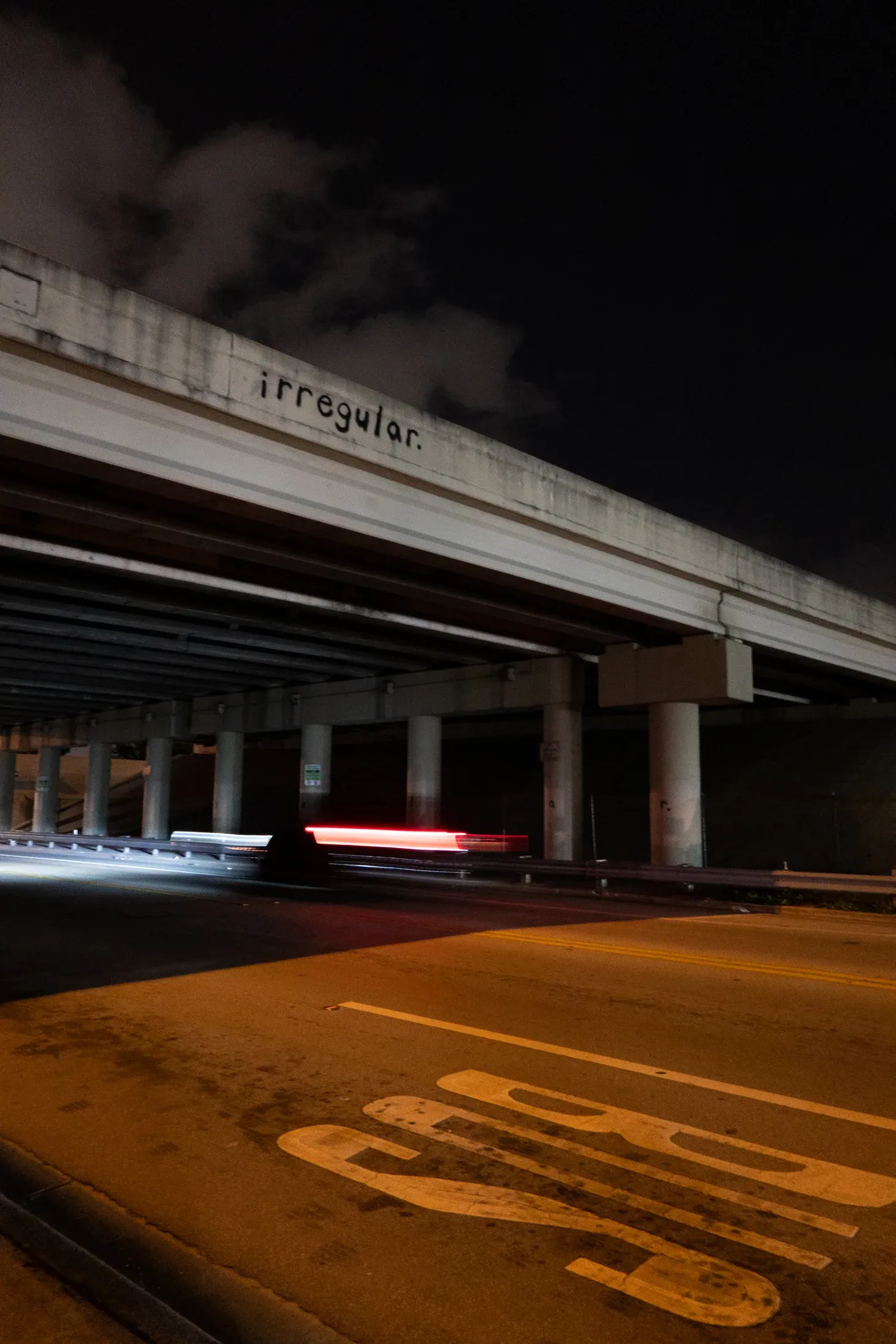 The overpass and roadway opening into the city at night.