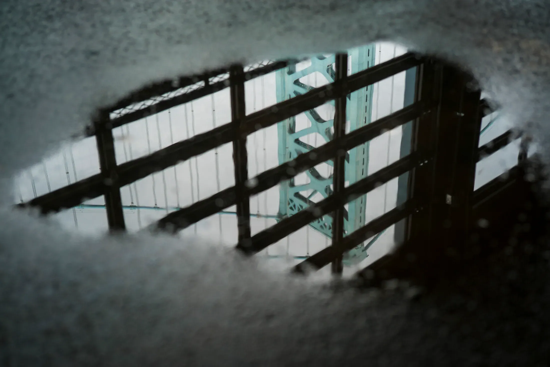A city structure reflected in wet pavement.