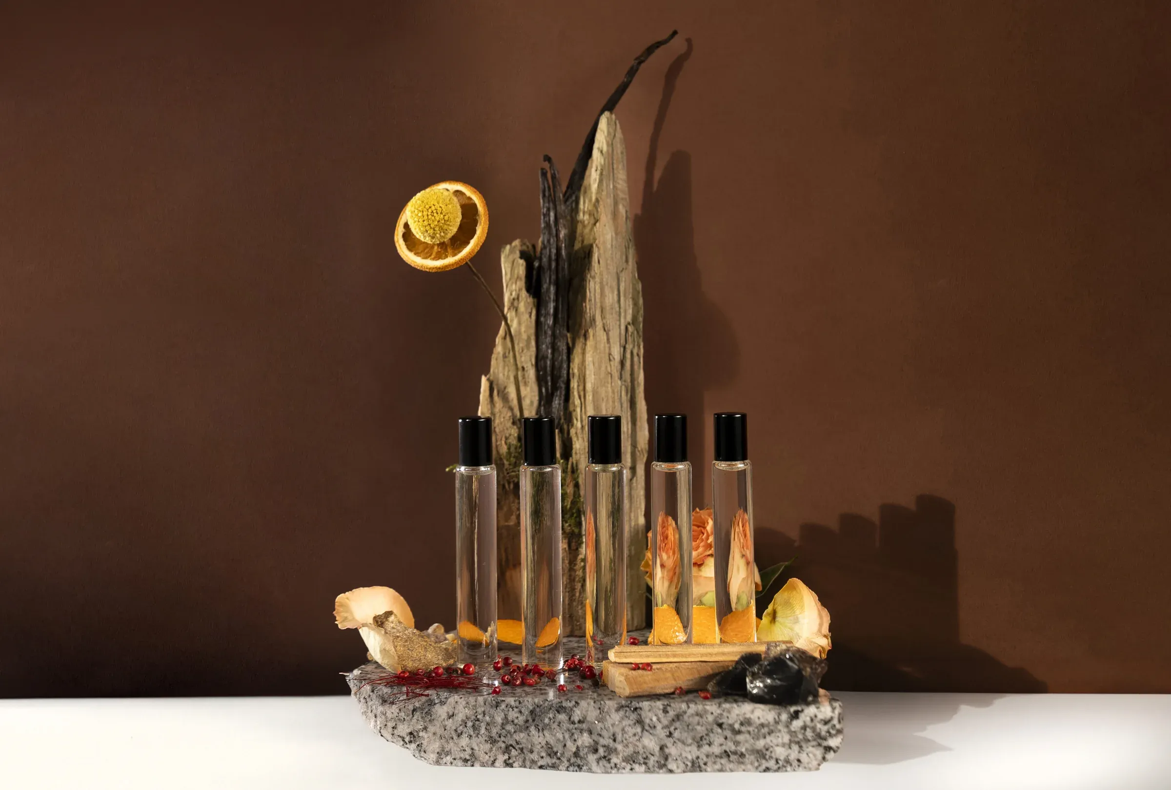 Fragrance oils styled with wood, dried citrus, and flowers.