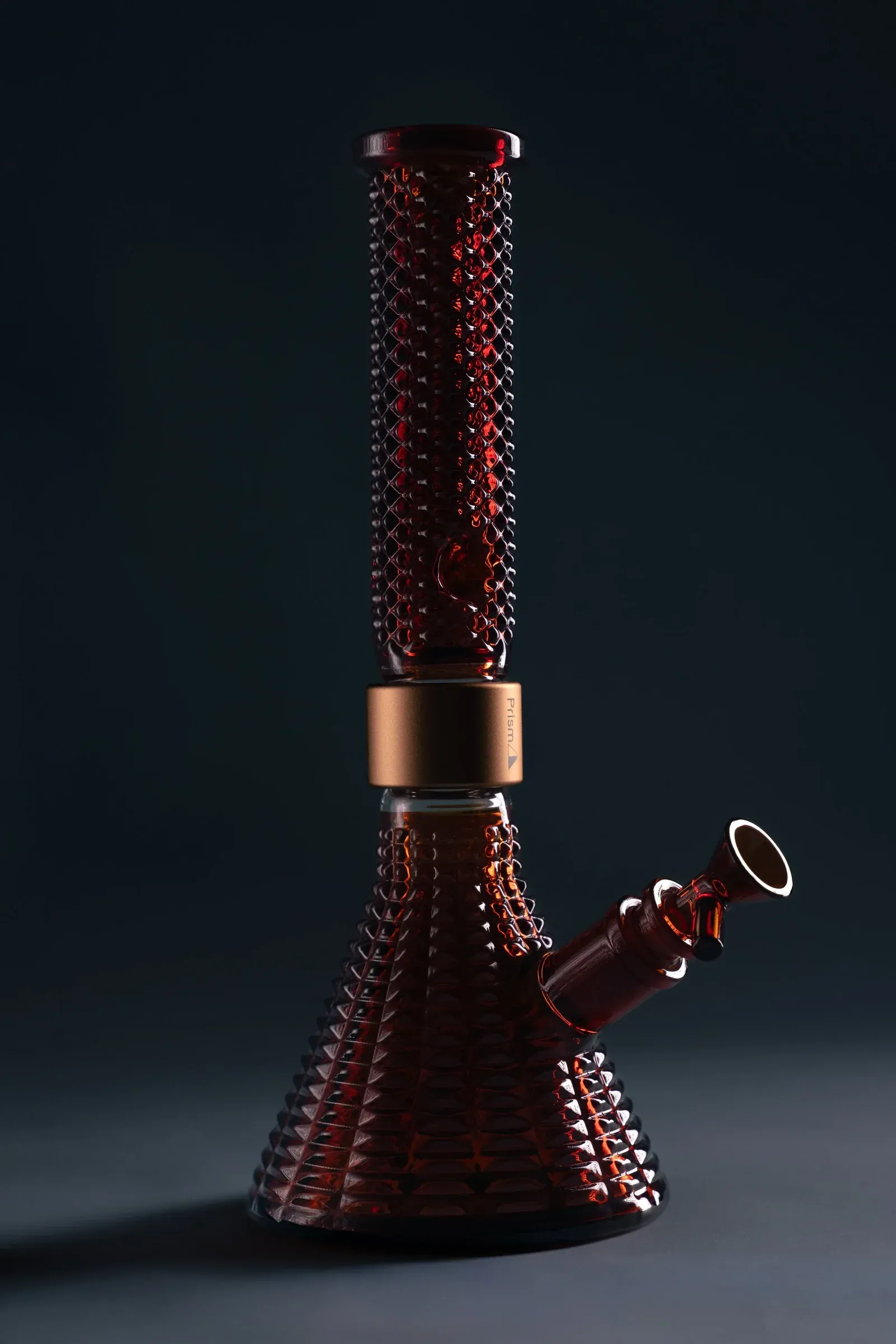 Red glass smoking piece photographed against a dark background.