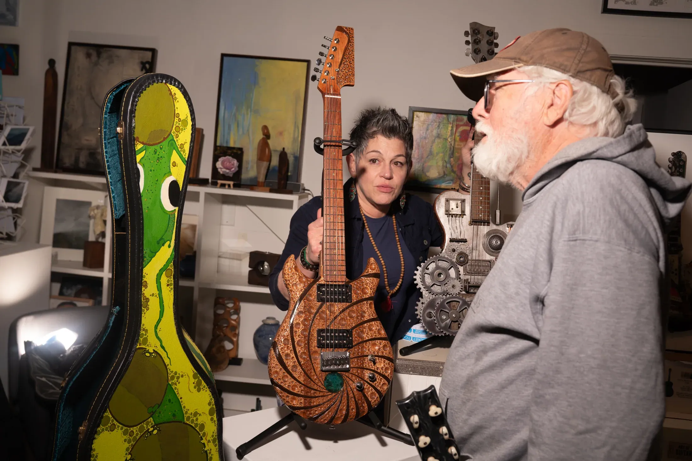 An artist working on a guitar during The Art of Guitar program.