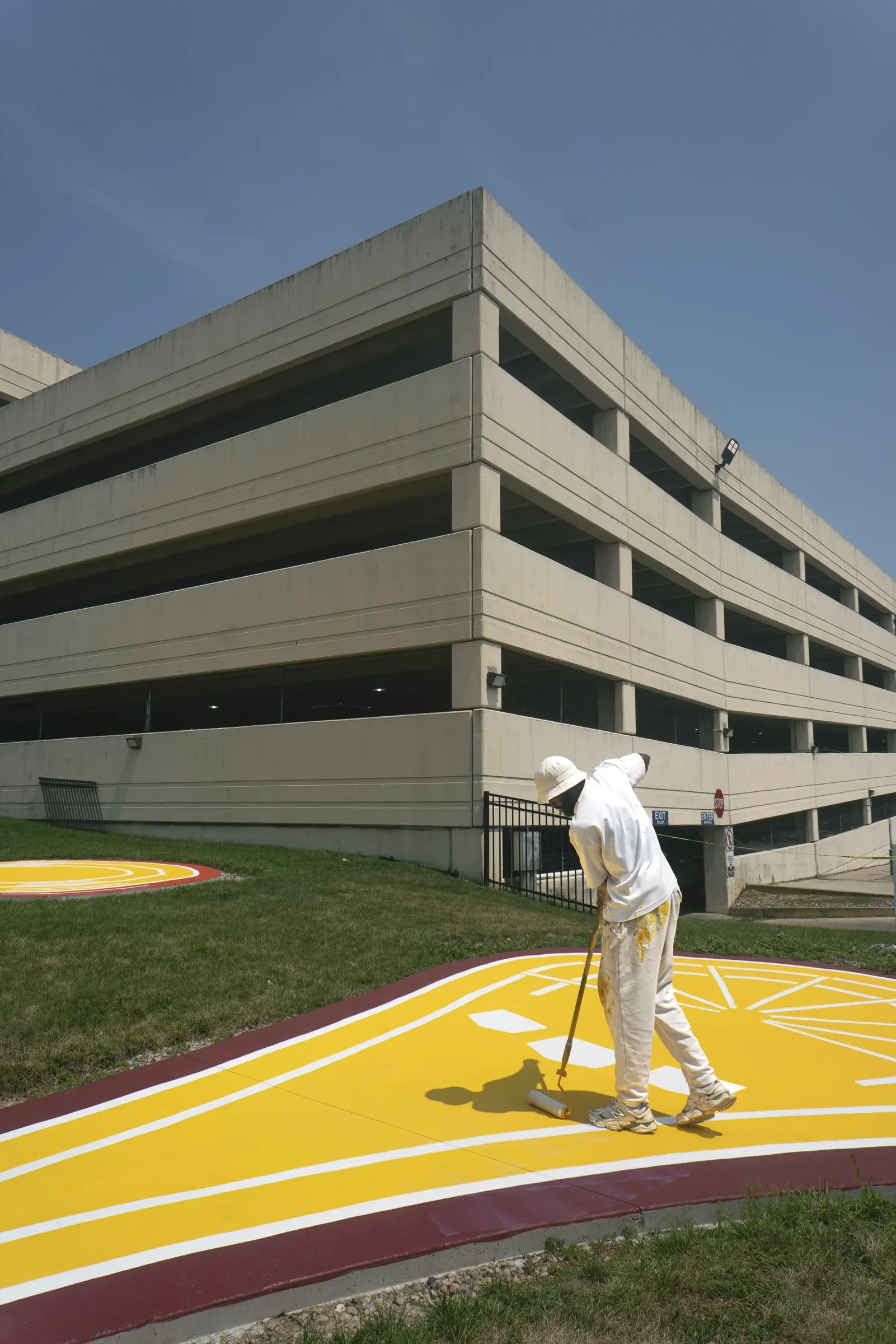 Andre Chaney painting a brightly colored public basketball court.